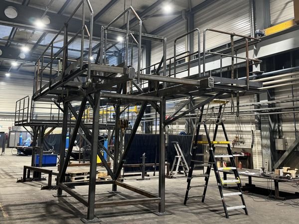 Konepajalla valmistettu teräksinen tasorakenne kaiteineen ja portaineen.